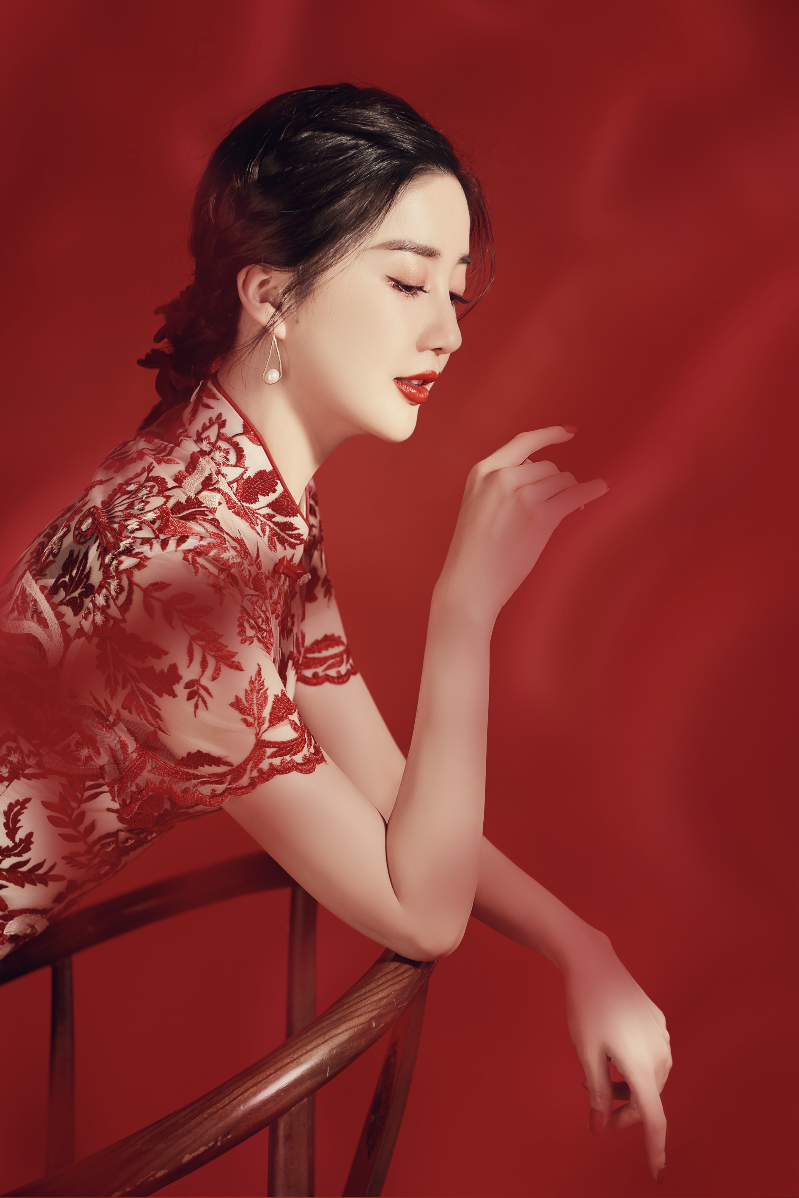 陈欣予一袭红色刺绣旗袍,既复古又摩登,精致的编发用蝴蝶结发饰盘成